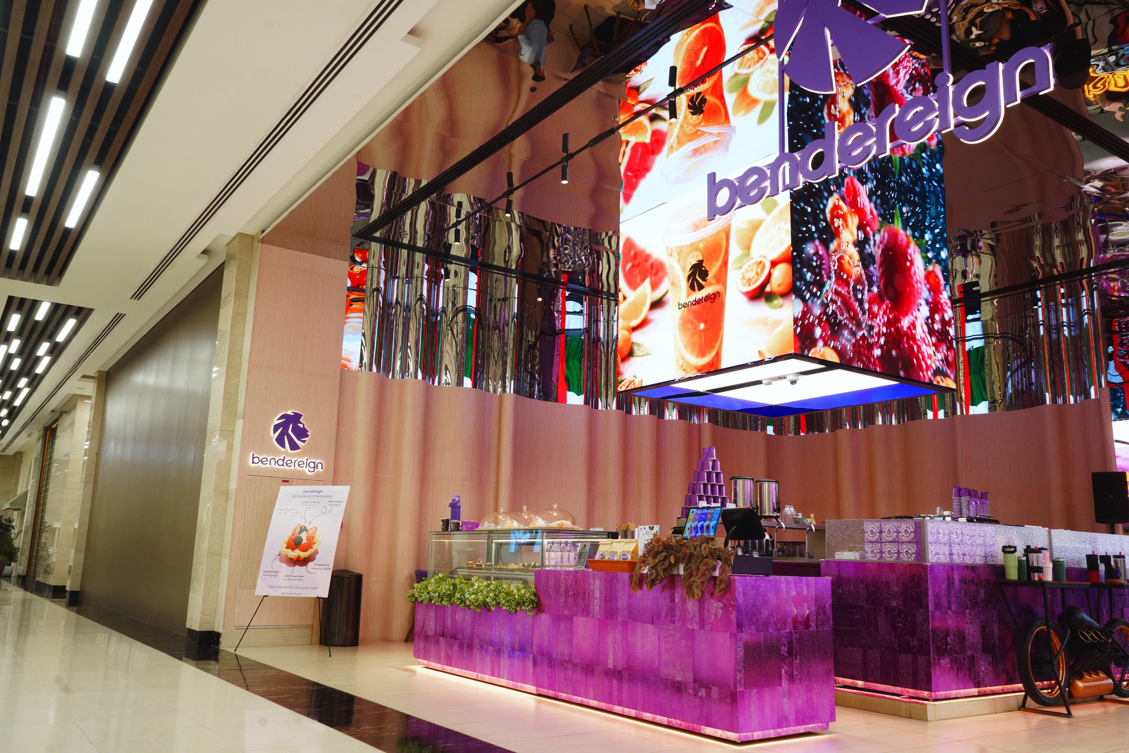 The Bendereign fascia — mirrored chrome ceiling, backlit fruit screens and the magenta resin counter.